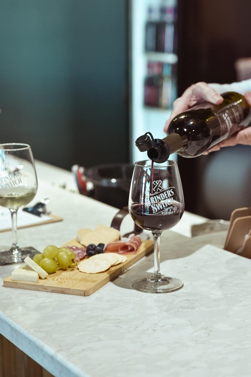 Grinder's Switch Winery in Columbia poured into a glass with charcuterie board